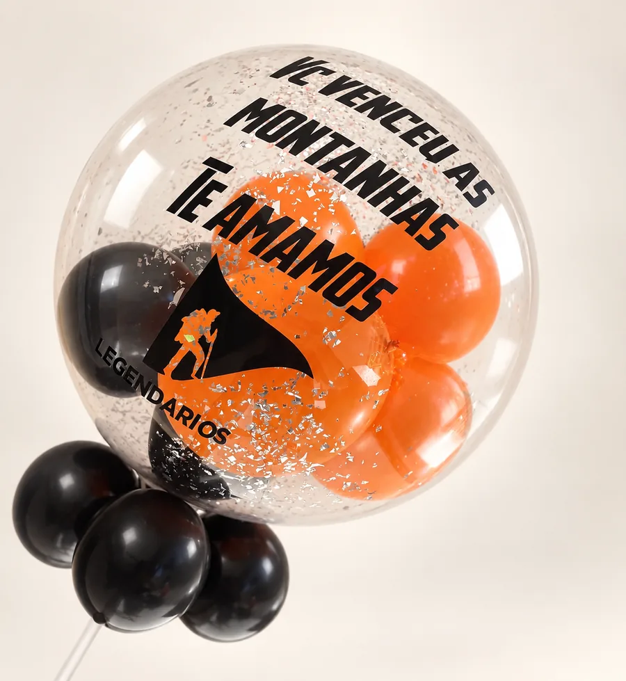 Balão bubble escrito Você venceu as montanhas, te amamos, com a logo Legendários e balões laranja e pretos dentro.