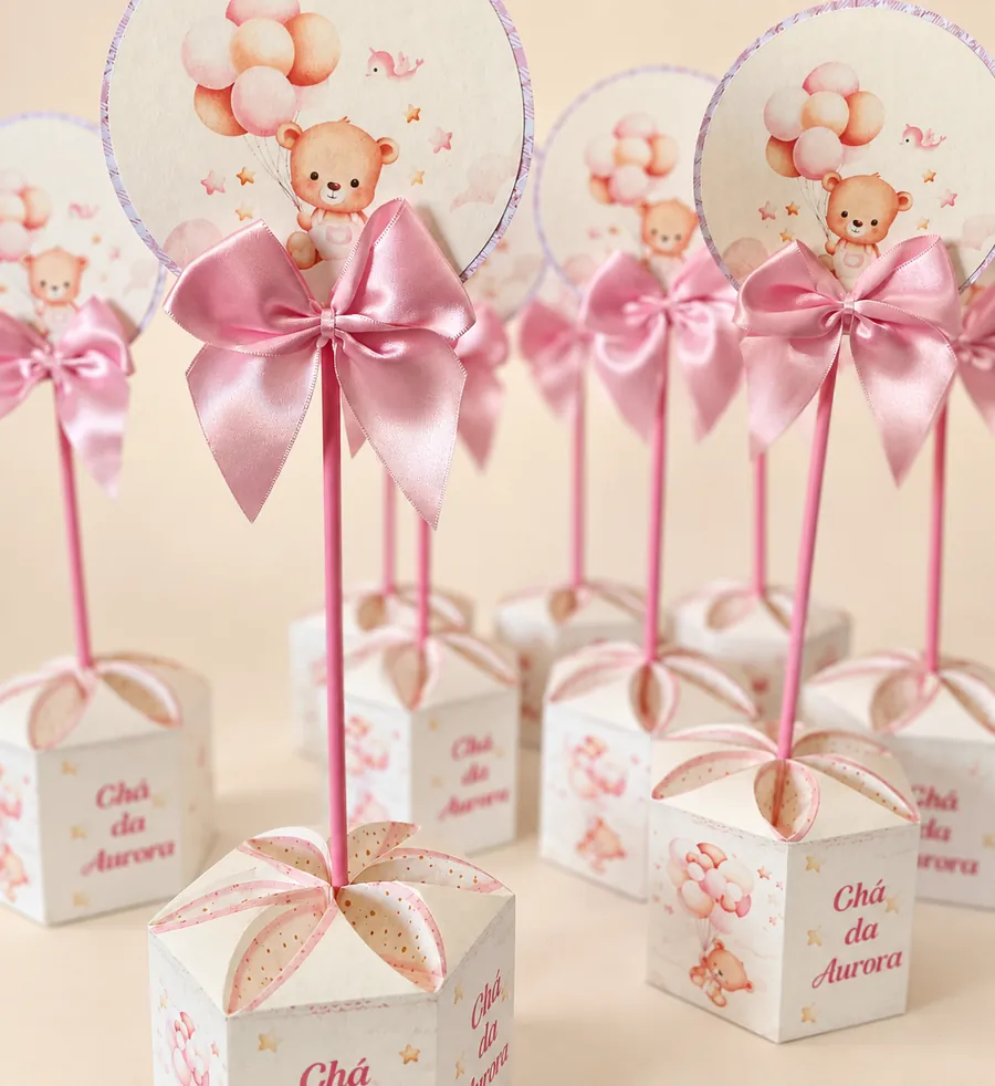Caixinhas brancas com tampa em pétalas e palito com topo redondo de ursinho com balões e laço rosa, escritas Chá da Aurora.